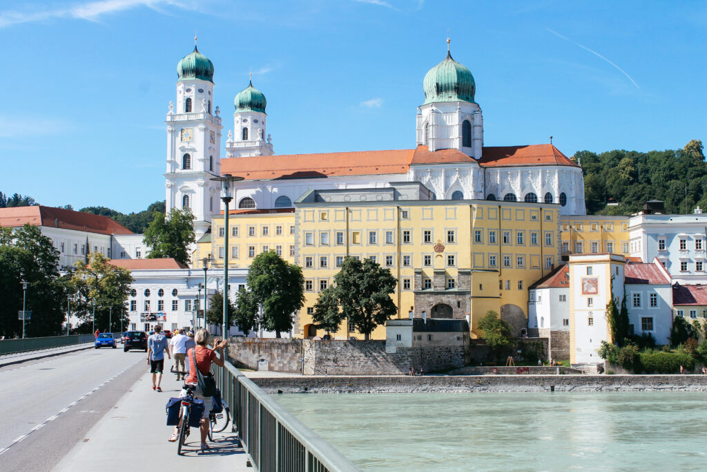 Cycle tourist stops to photograph Passau, baroque St. Stephen's Cathedral, Danube river, Austria