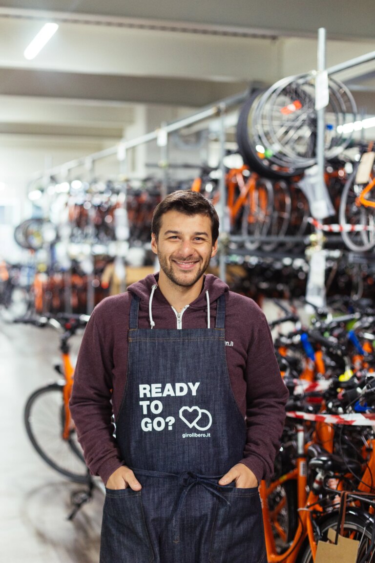 Smiling mechanic in the Girolibero bike shop in Vicenza, surrounded by bicycles